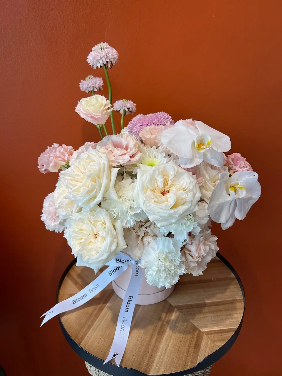 Pastel pink and white arrangement with phalaenopsis orchids, roses and ranunculus